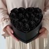Herzförmige Rosenbox mit schwarzen Infinityrosen wird in den Händen gehalten