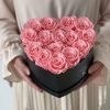 Herzförmige Rosenbox mit pinken Infinityrosen wird in den Händen gehalten