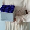 Eckige Rosenbox mit Samtfinish und blauen Infinityrosen wird von einer Frau in den Händen gehalten