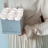 Eckige Rosenbox mit Samtfinish und weißen Infinityrosen wird von einer Frau in den Händen gehalten