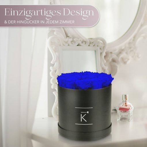 Kleine runde Rosenbox in schwarz mit blauen Infinityrosen, die auf dem Schminktisch steht