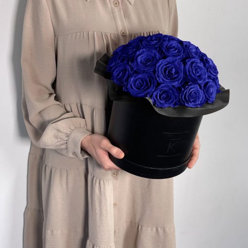 Gorgeuos Rosenbox rund mit blauen Infinityrosen wird von einer Frau in ihren Händen gehalten