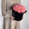 Gorgeuos Rosenbox rund mit pinken Infinityrosen wird von einer Frau in ihren Händen gehalten